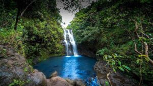 ground view of blue water pool with Waimano Falls in the background in Oahu, Hawaii, USA